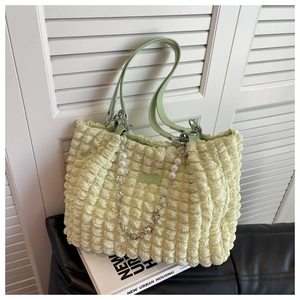 Detail of yellow puffer cloud tote bag with mint green handle and pearl flower chain