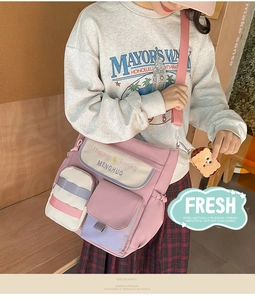 Close-up of pink and purple oxford tote bag with multiple pockets and toast charm detail