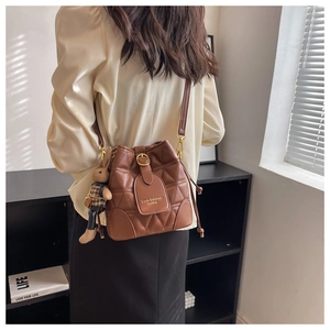 Brown quilted bucket bag featuring a gold chain strap and a cute plush bunny charm