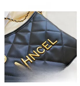 Detail of black quilted leather shoulder bag with gold chain and AHNCEL metal logo