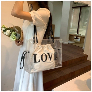 Transparent PVC tote bag with a white LOVE embroidery inner pouch shown on a model