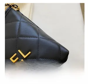 Detail showing the quilted leather texture and gold chain strap of the black bucket bag