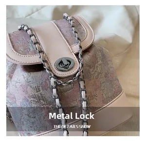 Detail of pink floral jacquard backpack featuring silver turn-lock and chain strap