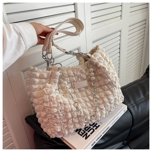 Detail of white bubble texture tote bag with pearl charm and metal chain strap