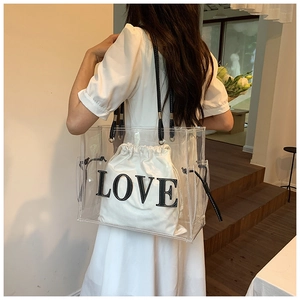Detail view of transparent PVC tote bag featuring white canvas LOVE inner pouch