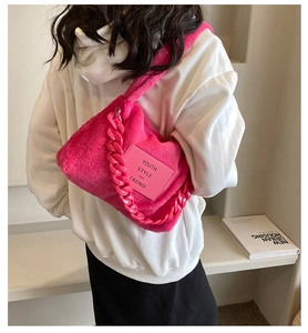 Close-up of fluffy magenta plush tote bag with thick chain strap and youth style label
