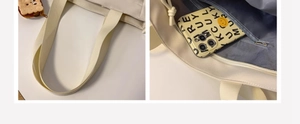 Detail view of thickened woven shoulder strap and secure inner zipper pocket on white tote bag