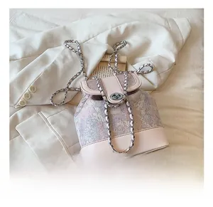Detail of pink jacquard bucket bag with metallic chain and classic twist lock closure