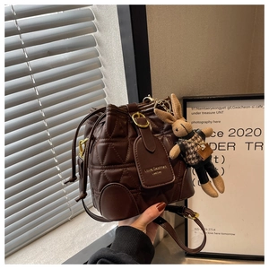 Brown quilted bucket bag with golden buckle and cute rabbit doll charm detail
