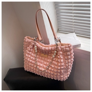 Detail of pink puffy tote bag with bubble texture and decorative pearl metal chain