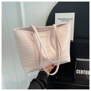 Detail showing high-quality crocodile pattern leather and gold logo on pink tote bag