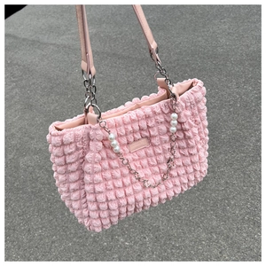 Detail showing pink bubble textured fabric with silver chain and pearl decorations