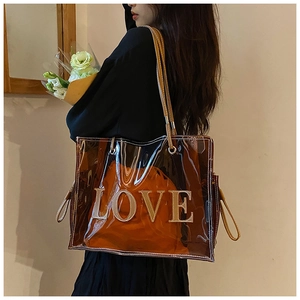 Detail view of large brown transparent PVC tote bag with LOVE lettering and inner pouch