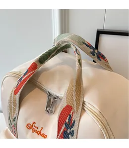 Détail du sac en toile avec poignée brodée à motif floral et broderie logo précise