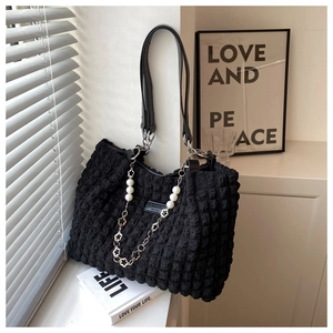 Detail of black cloud tote bag with bubble texture and pearl flower chain decoration