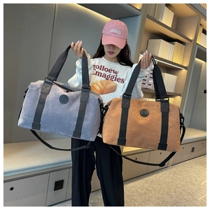 Detail of grey and tan large travel bags with canvas texture and durable straps