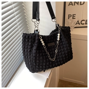 Detail of black bubble texture tote bag featuring pearl and floral chain decoration