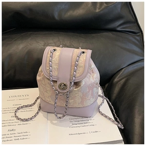 Detail of lavender textured fabric and chain strap on a stylish mini bucket backpack