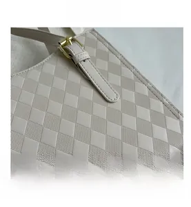 Close-up of beige faux leather tote bag showing diamond quilted texture and gold hardware