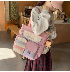 Macro detail of pink Oxford tote bag featuring multi-pocket design and cute charm pendant