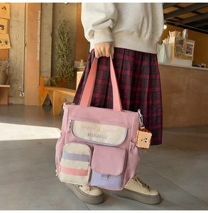 Close-up of pink oxford tote bag details with cute embroidery and a plush bread charm