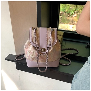 Detailed shot of purple jacquard fabric backpack with gold embroidery and chain strap