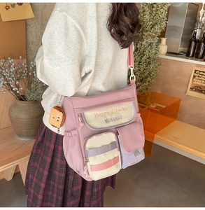 Detail of oxford tote bag featuring pink and purple patchwork with a cute plush pendant
