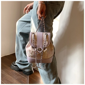 Detail of lavender mini chain backpack with floral embroidery and gold twist lock clasp