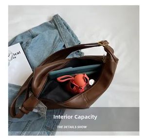 Interior view showing large capacity of the brown crescent bag with daily essentials