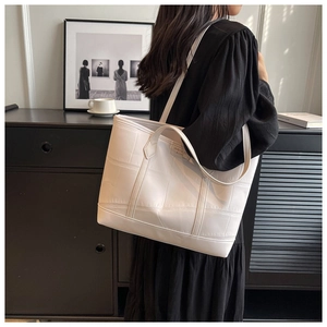 Close-up of white crocodile pattern tote bag showing fine stitching and luxury texture