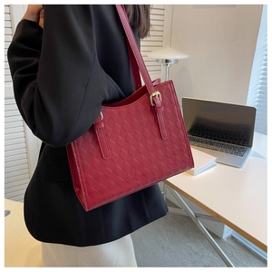 Detail of red quilted leather tote bag with gold hardware and adjustable strap