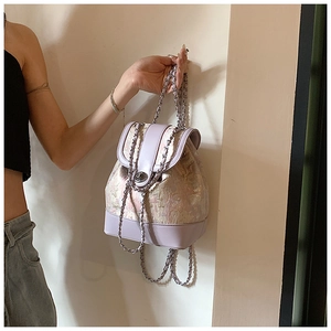 Detail of lavender jacquard drawstring bucket bag with silver chain strap and metal lock