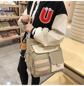 Detailed shot of beige nylon tote bag with utility pockets and plush toast charm