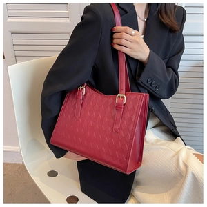 Detail of red woven texture on a large tote bag with elegant gold buckle on the shoulder strap