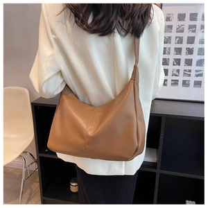 Modern caramel brown hobo bag with smooth texture and wide strap for daily commute