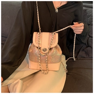 Detail of pink pearlescent mini backpack with silver chain strap and metal swivel lock