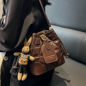 Dark brown quilted bucket bag with diamond stitching and cute rabbit charm pendant