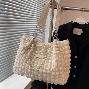 Minimalist beige cloud tote bag with bubble pleat texture and metal chain strap