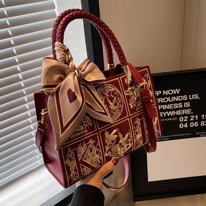 Elegant red leather tote bag with gold bird embroidery and decorative heart print scarf