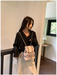 Detail of pink chain backpack with artistic pattern and metal twist lock closure