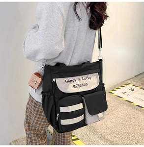 Detail view of the black and white contrast oxford tote bag with side pocket and cartoon charm