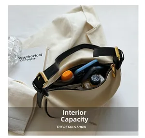 Top-down view of spacious beige crescent bag interior holding daily essentials