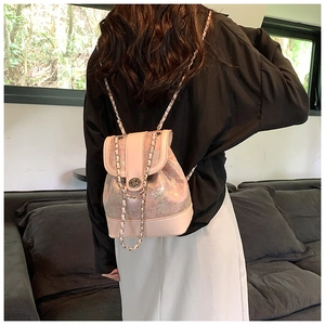 Rear view of a pink pearlescent mini chain backpack featuring a silver twist lock on the flap