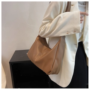 Close-up of a brown leather hobo bag shoulder strap and premium smooth texture