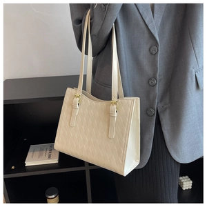 Detail of adjustable golden buckle and quilted beige texture on tote shoulder bag