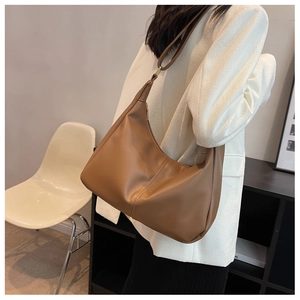 Detailed side view of a brown minimalist hobo bag with sleek stitching and adjustable strap