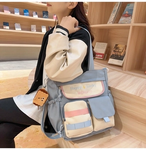 Detailed view of color-block Oxford tote bag with multiple pockets and plush toast charm