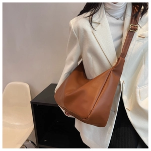 Close-up of brown hobo bag with wide shoulder strap and gold metallic buckle detail