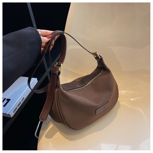 Close-up of brown crescent bag showing waterproof nylon texture and leather strap