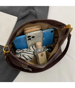 Detail view of large brown shoulder bag interior storage for tablet and essentials